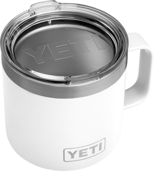 Der YETI® Tasse Rambler 10 Oz - Weiß hat einen durchsichtigen Kunststoffdeckel, einen stabilen Griff und einen eingravierten YETI-Schriftzug sowohl auf dem Deckel als auch auf der Vorderseite.