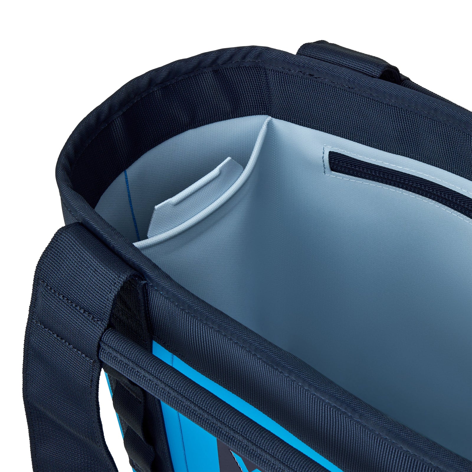 Eine Nahaufnahme der YETI® Tragetasche Camino® Carryall 20 in Big Wave Blue zeigt ihr hellblaues Innenfutter, eine kleine Innentasche und robuste dunkle Griffe.