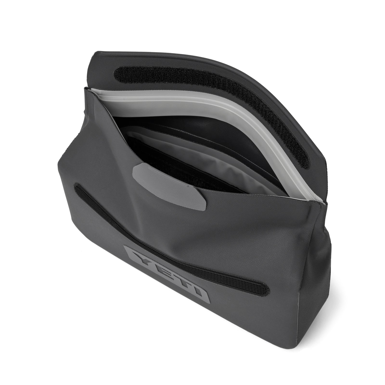 Eine anthrazitfarbene YETI® Zubehörtasche - Sidekick® 1L mit Klettverschluss und unterteiltem Innenraum bietet wasserdichten Stauraum für Outdoor-Abenteuerausrüstung. Die rechteckige Tasche verfügt über einen YETI Logoaufnäher auf der Außenseite.