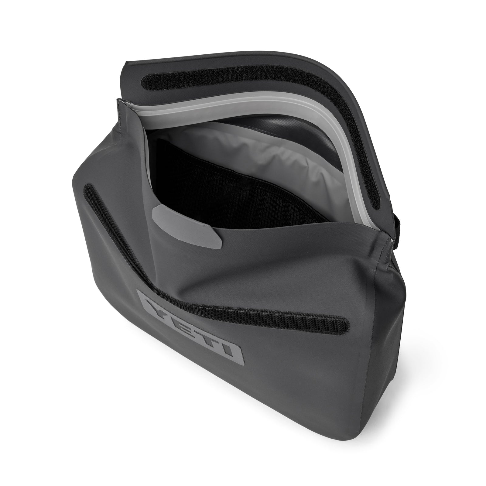 Die schwarze YETI® Zubehörtasche - Sidekick® 6L wird mit Reißverschluss und Klettverschluss geöffnet und offenbart einen geräumigen, wasserdichten Innenraum mit Netztasche und dem YETI-Logo auf der Vorderseite - perfekt für Outdoor-Ausrüstung.