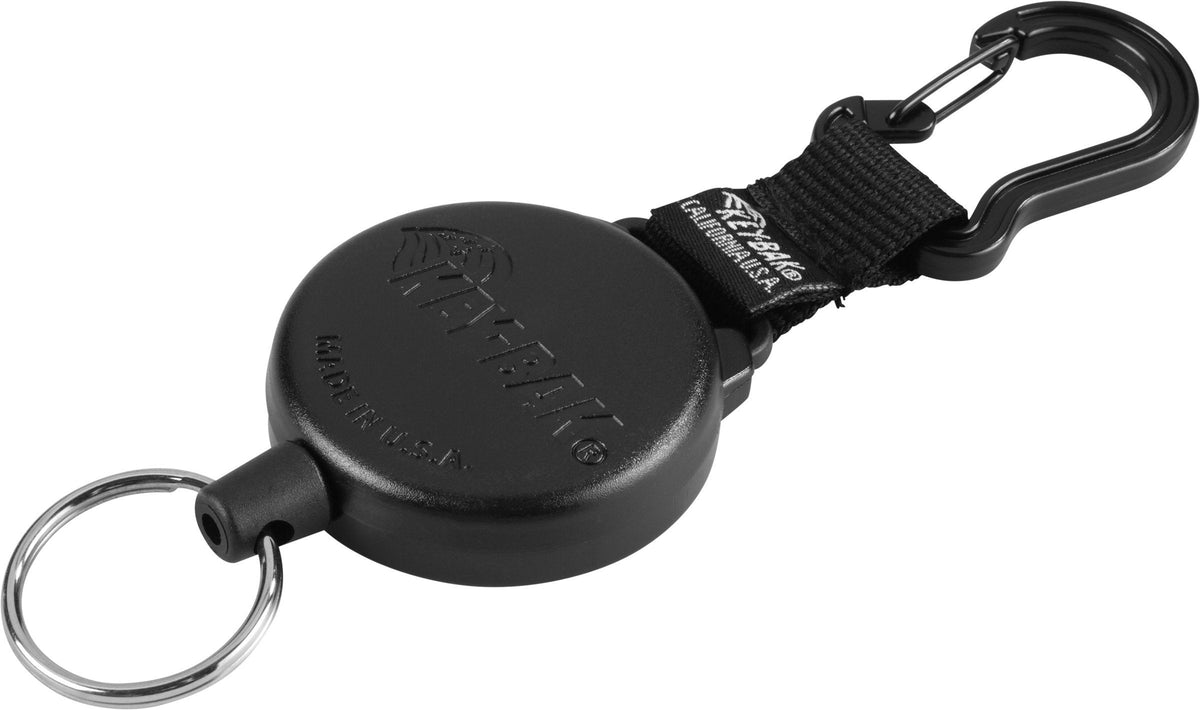 Der KEY-BAK Key-Bak Schlüsselhalter ist ein schwarzer, ausziehbarer Ausweishalter mit rundem Gehäuse, Schlüsselring, Nylonband und Aluminium-Karabiner-Schlüsselhalter nach dem Vorbild des Key-Bak SecurIT Modell 488.