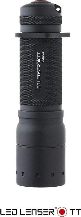 Eine schwarze LEDLENSER Ledlenser Taschenlampe TT steht aufrecht, mit einem strukturierten Griff und dem LEDLENSER-Logo an der Seite. Der Name Ledlenser Taschenlampe TT erscheint am unteren Rand des Bildes dieser robusten Taschenlampe.