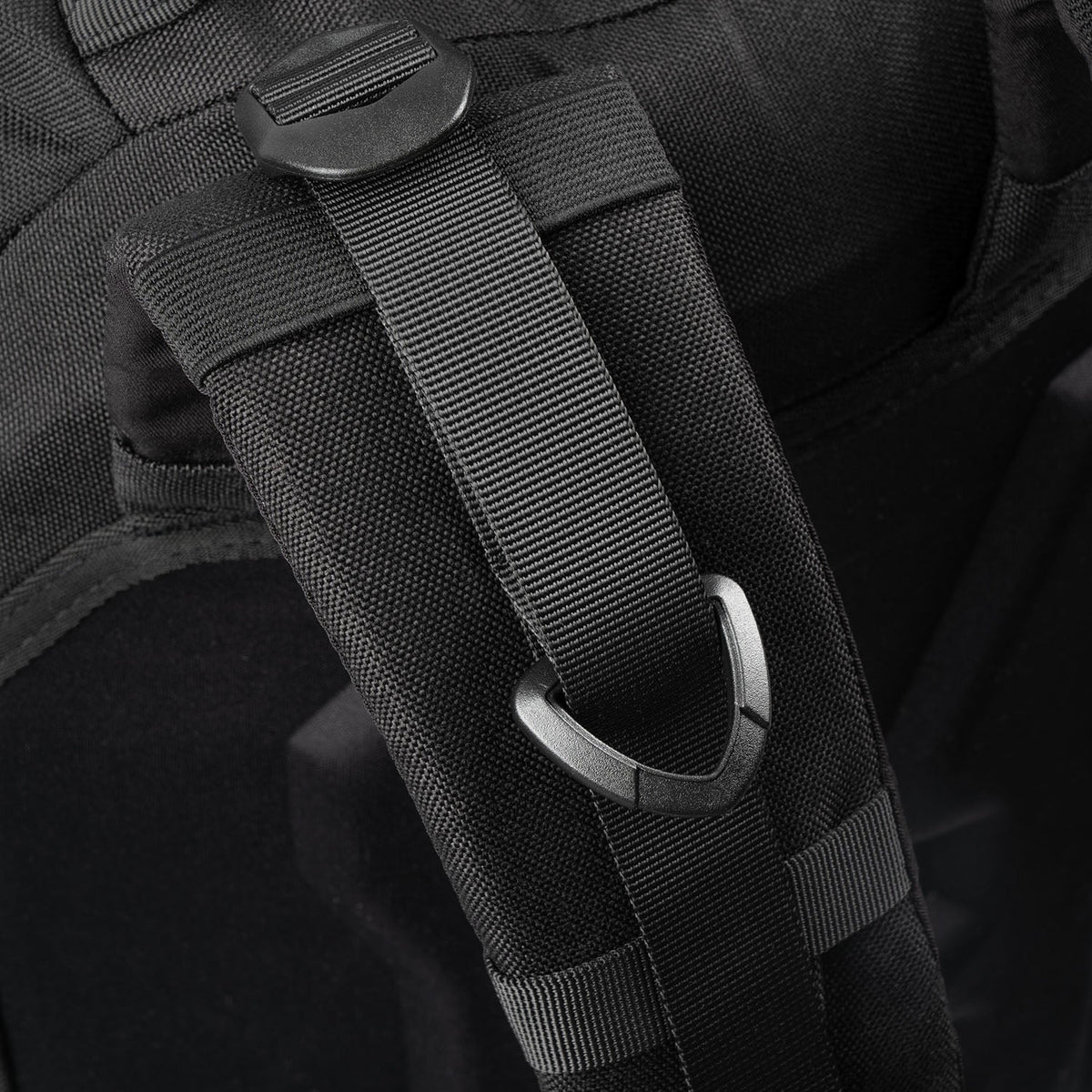 Nahaufnahme des STOIRM 25L Tactical Pack GEN2 von STOIRM in Ranger Green, die den strapazierfähigen 1000D-Nylon-Riemen mit Kunststoff-Verstellschnalle und dreieckigem Metallring sowie detaillierte Nähte zeigt.