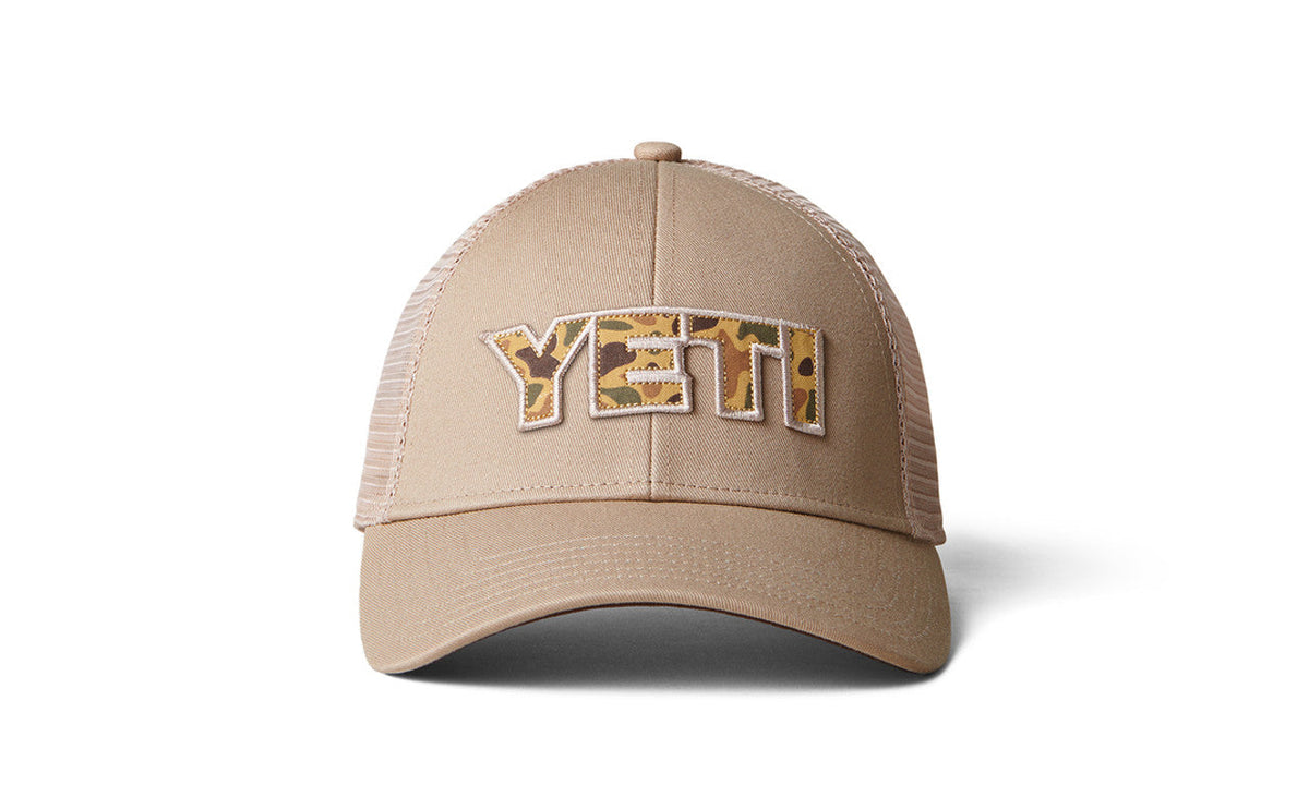 Die YETI® Camo Logo Badge Trucker Cap verfügt über Mesh-Einsätze auf der Rückseite, ein auffälliges Camo-Patch-Logo und wird aus recycelten Fischernetzen hergestellt, um Nachhaltigkeit zu gewährleisten.