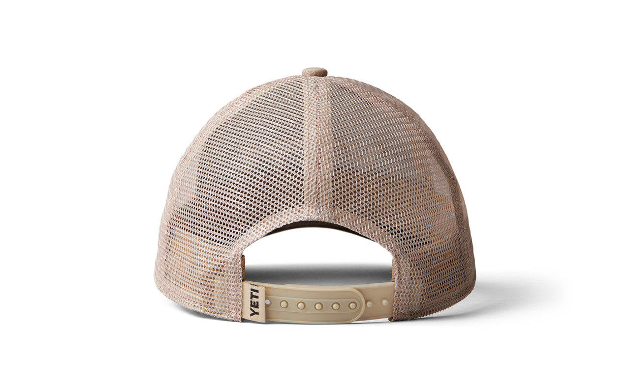 Die Abbildung zeigt die Rückseite der YETI® Camo Logo Badge Trucker Cap mit beigem Mesh, einem verstellbaren Snapback-Verschluss und einem YETI-Tag auf der Rückseite.