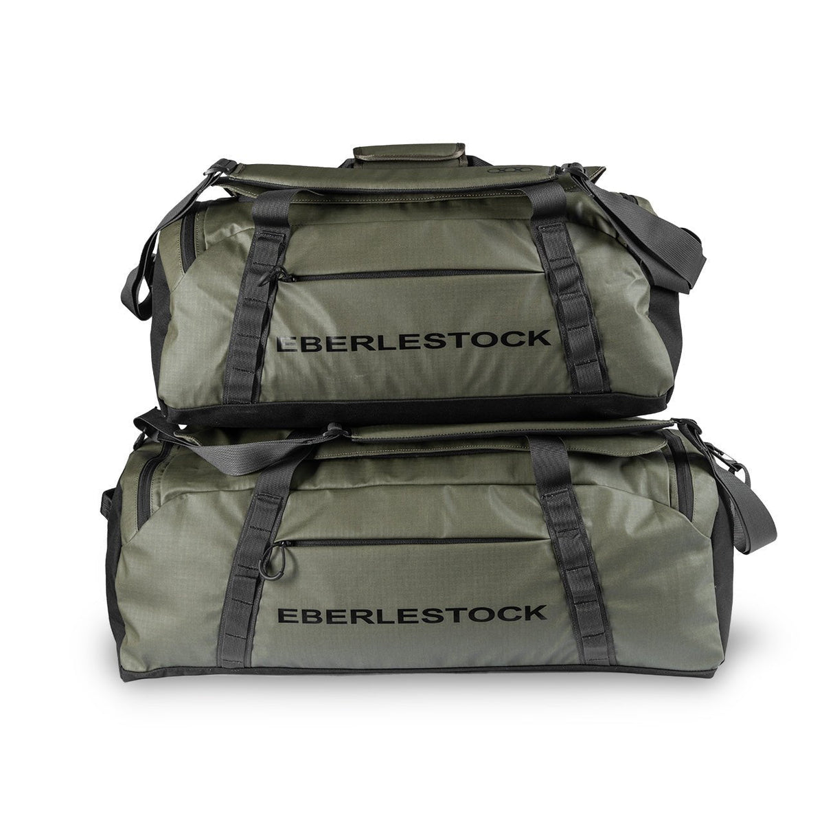 Zwei militärgrüne EBERLESTOCK Hyllus Duffel 65 Taschen mit schwarzen Trägern und Reißverschlüssen sind vor einem weißen Hintergrund gestapelt.