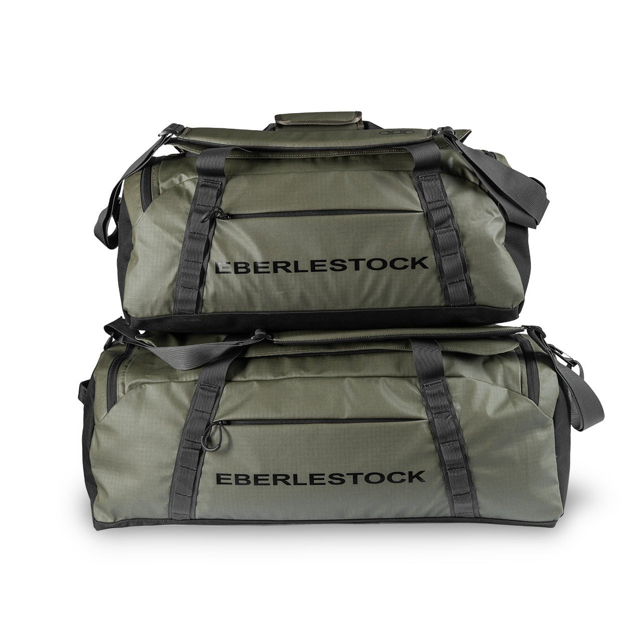 Zwei militärgrüne EBERLESTOCK Hyllus Duffel 65 Taschen mit schwarzen Trägern und Reißverschlüssen sind vor einem weißen Hintergrund gestapelt.