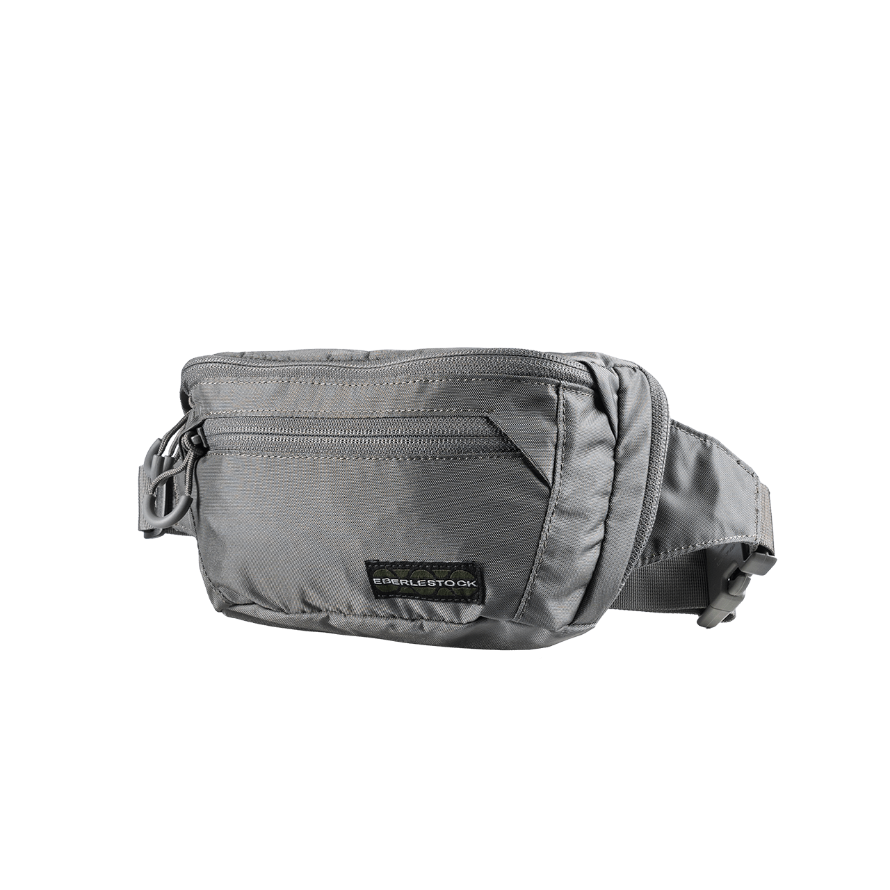 Die EBERLESTOCK Bando Bag Standard in grau ist eine Hüfttasche mit Reißverschlussfächern, einem verstellbaren Gurt und einem schwarzen Label auf der Vorderseite - perfekt als CCW-Umhängetasche zum verdeckten Tragen von Essentials.