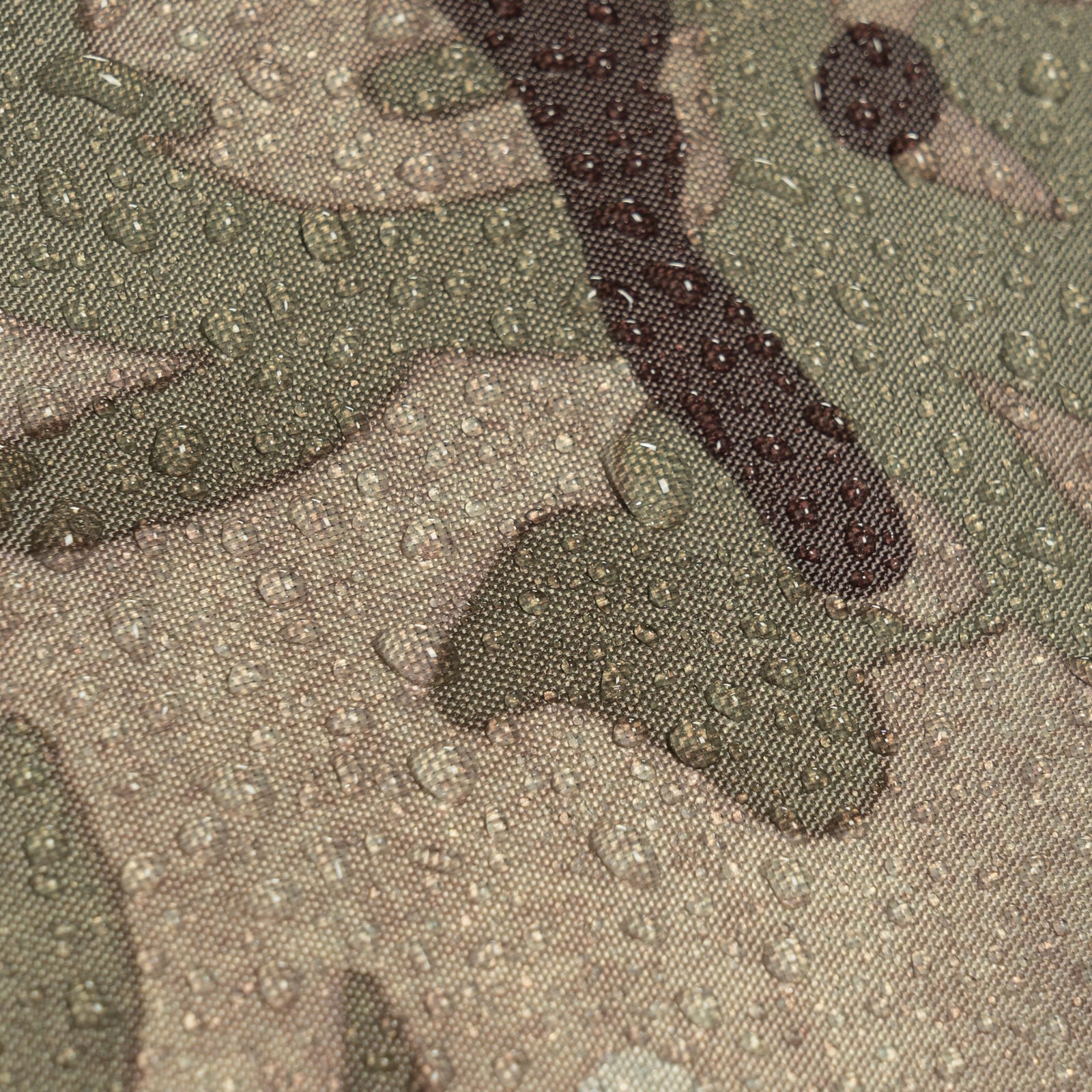 Nahaufnahme von Wassertropfen auf dem Tarnstoff von HIGHLANDER FORCES Highlander Zelt Blackthorn 1+ Gen2 - HMCT, die die Wasserfestigkeit des Stoffes hervorheben. Das Design zeigt unregelmäßige grüne, braune und hellbraune Formen.