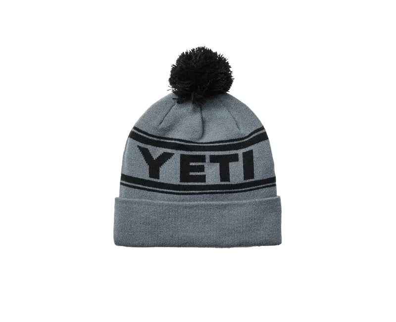 Mit der YETI® Logo Retro Knit Beanie bleiben Sie die ganze Saison über warm und stylisch - eine graue Strickmütze mit schwarzem Bommel, schwarzem YETI-Schriftzug auf einem Retro-Streifen und einem umgeschlagenen Bündchen.