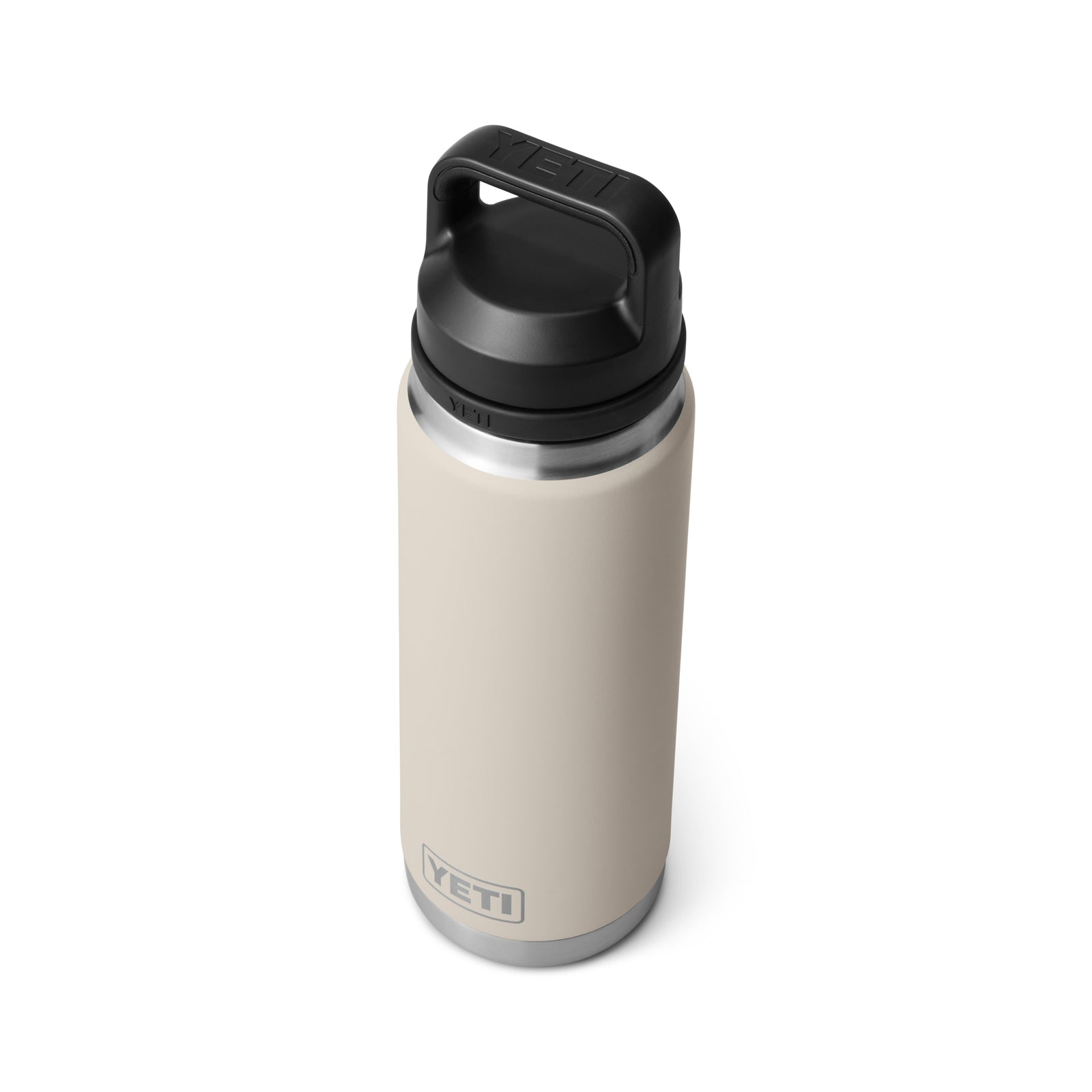 Eine YETI® Flasche Rambler 26 Oz in Cape Taupe mit schwarzem Schraubdeckel und Griff ist auf weißem Hintergrund abgebildet. Ihre doppelwandige Vakuumisolierung und das YETI-Logo in der Nähe des Bodens sind deutlich sichtbar.
