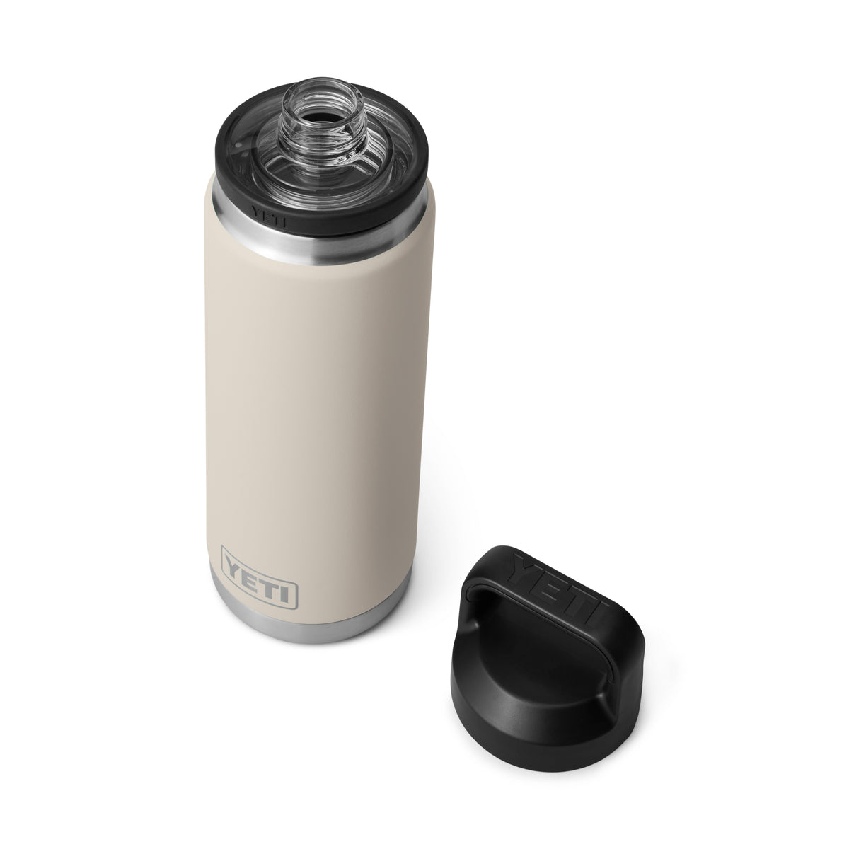 Eine YETI® Flasche Rambler 26 Oz - Cape Taupe mit doppelwandiger Vakuumisolierung und Edelstahlrand wird geöffnet mit ihrem schwarzen Schraubdeckel daneben auf weißem Hintergrund gezeigt. Die Trinkflasche Edelstahl ist von oben betrachtet.