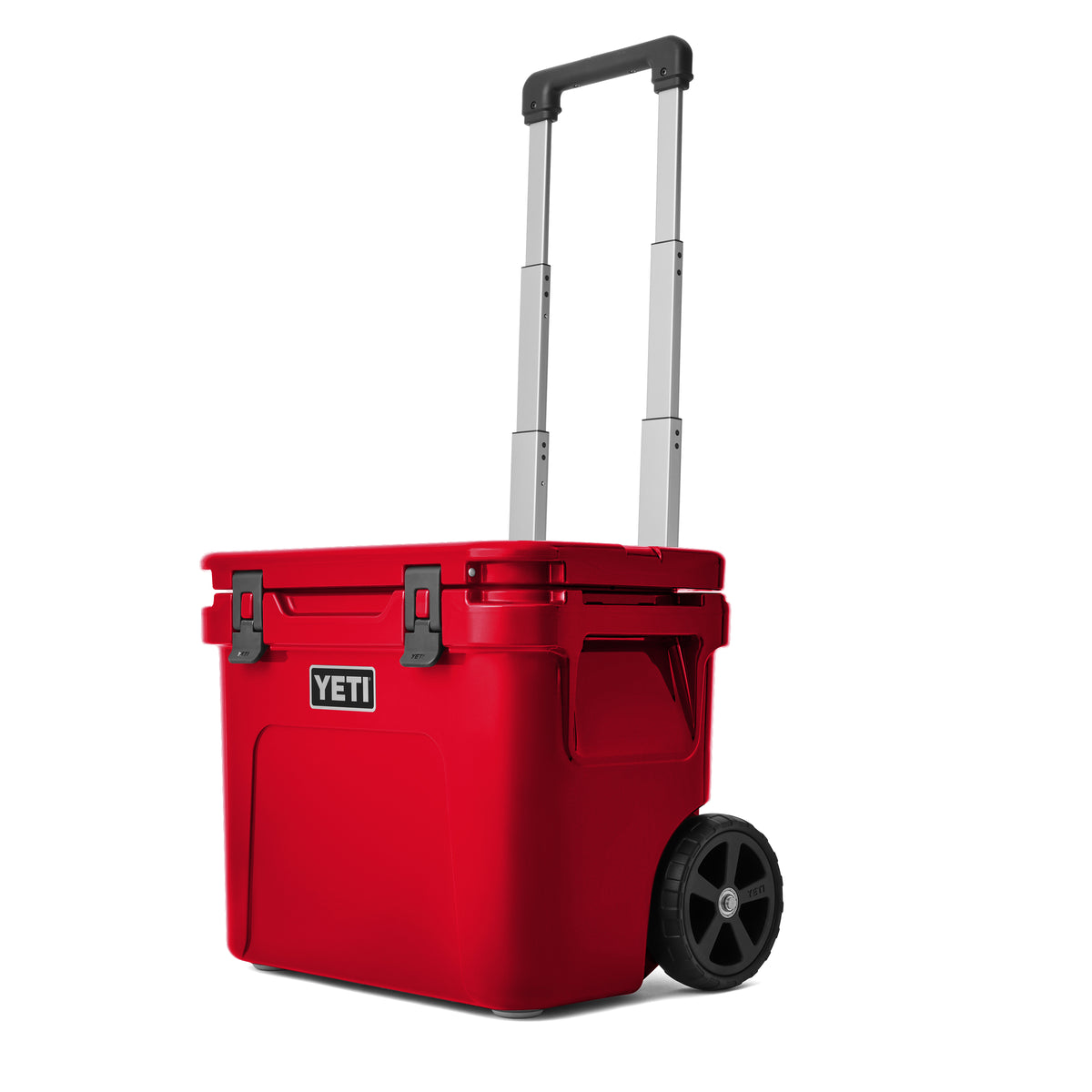 Die YETI® Kühlbox Roadie 32 - Rescue Red verfügt über einen einziehbaren Griff, zwei schwarze Frontverschlüsse und große Seitenräder für einen einfachen Transport.
