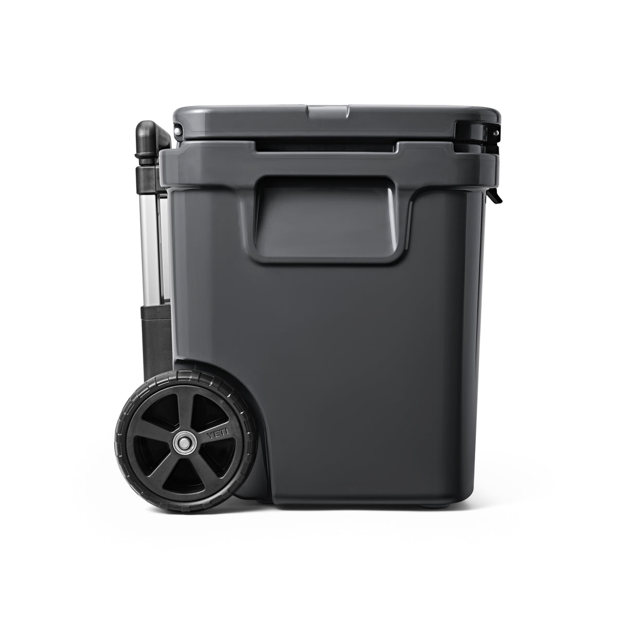 Ein großer, dunkelgrauer Behälter auf Rädern mit geschlossenem Deckel und zwei schwarzen Rädern steht vor einem weißen Hintergrund - wie die YETI® Kühlbox Roadie 60 - Charcoal von YETI.