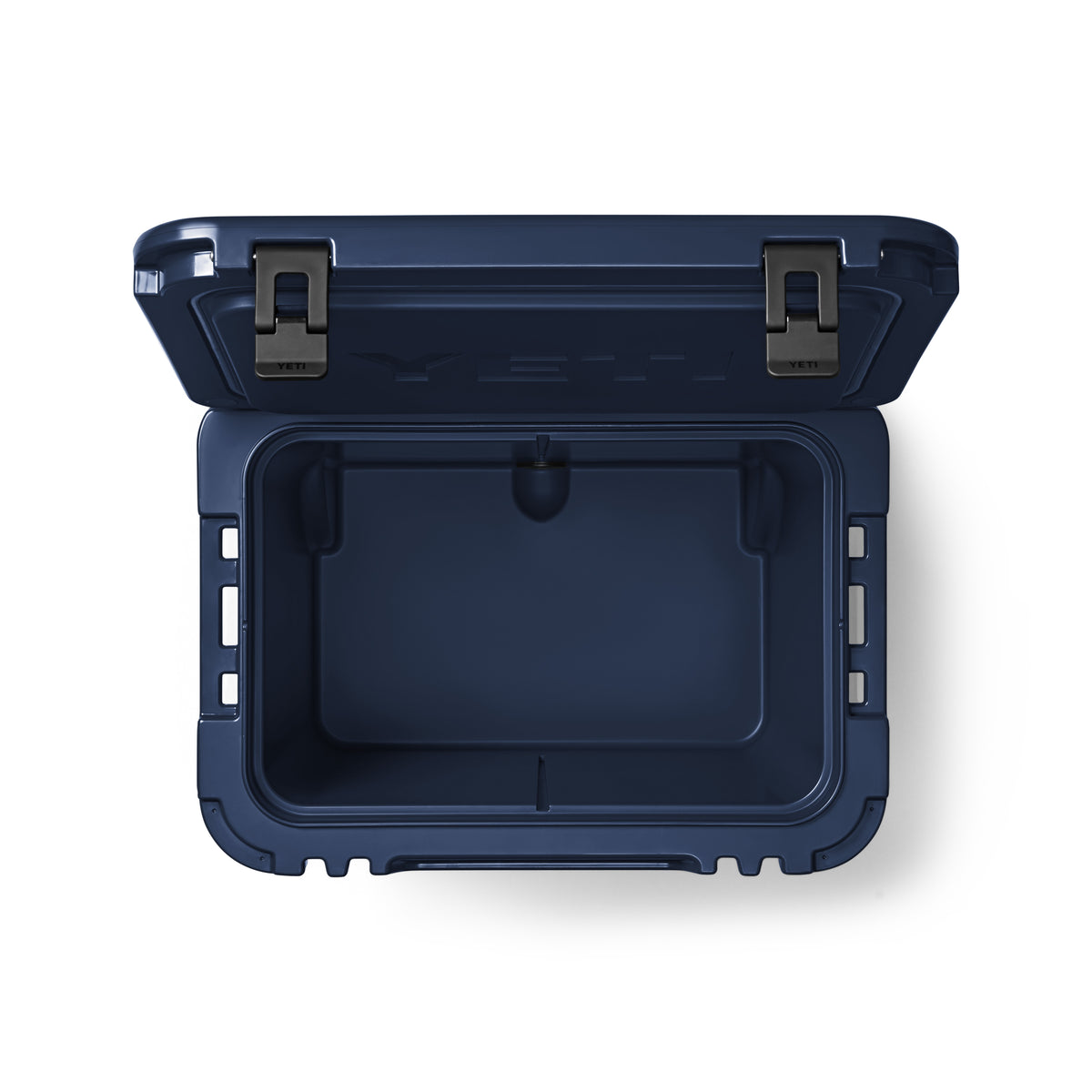 Die YETI® Kühlbox Roadie 60 - Navy von YETI, hier von oben mit geöffnetem Deckel und zwei schwarzen Frontverschlüssen, offenbart einen geräumigen Innenraum - ideal als robuste Camping-Kühlbox.