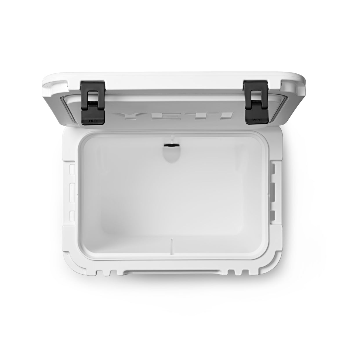Draufsicht auf die geöffnete YETI® Kühlbox Roadie 60 - White mit ihrem geräumigen, leeren Innenraum und den zwei schwarzen Verschlüssen - perfekt als Camping Kühlbox von YETI für Ihre Outdoor-Abenteuer.