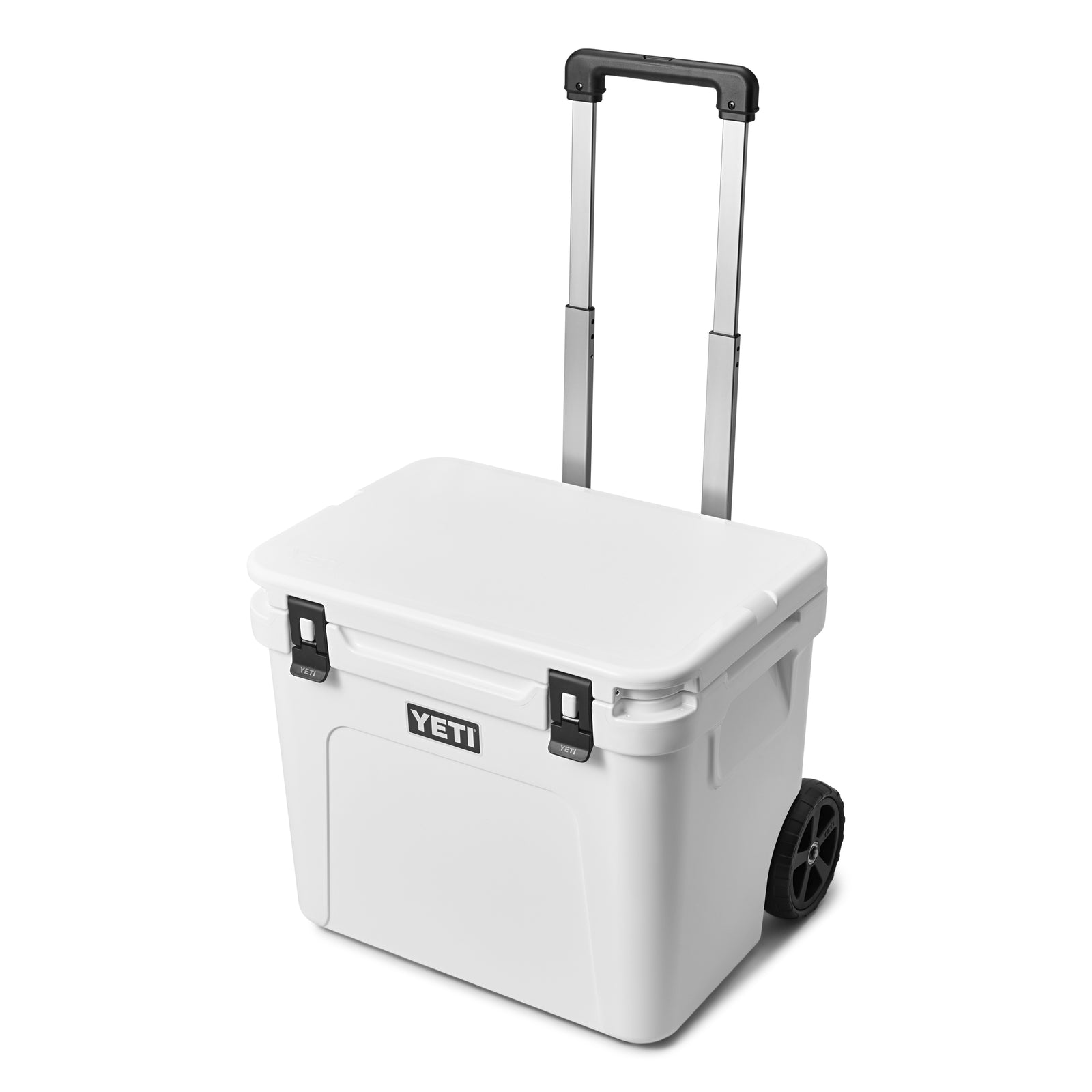 Die YETI® Kühlbox Roadie 60 - White verfügt über einen geschlossenen Deckel, zwei schwarze Verschlüsse, seitliche Griffe, große Räder und einen verlängerten schwarzen Teleskopgriff für einfachen Transport.