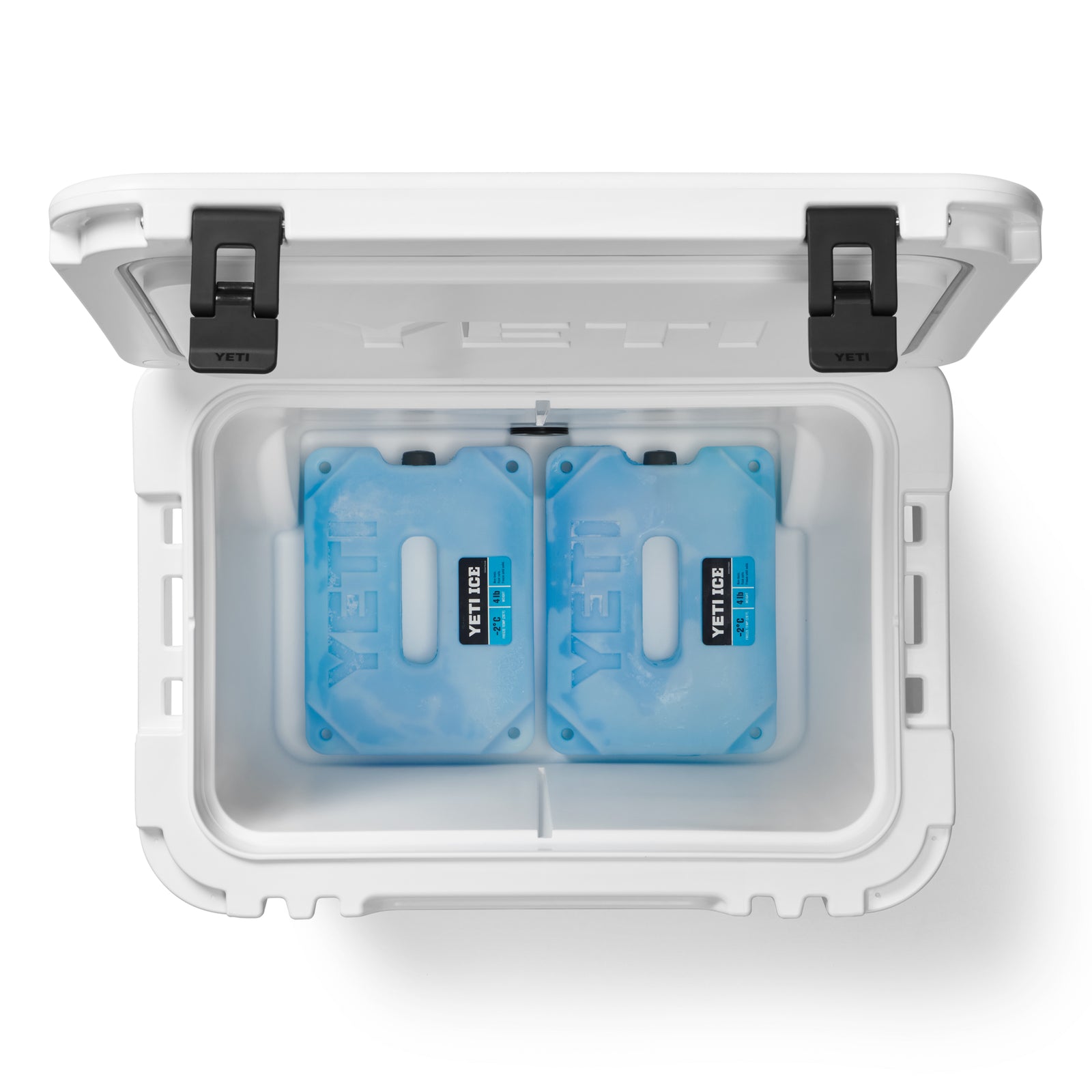 Die geöffnete YETI® Kühlbox Roadie 60 - White von YETI wird von oben gezeigt, mit zwei blauen Kühlakkus im Inneren, die ordentlich nebeneinander auf einem weißen Hintergrund platziert sind. Der Deckel der Kühlbox ist vollständig geöffnet und gibt den Blick auf das organisierte Innere frei.