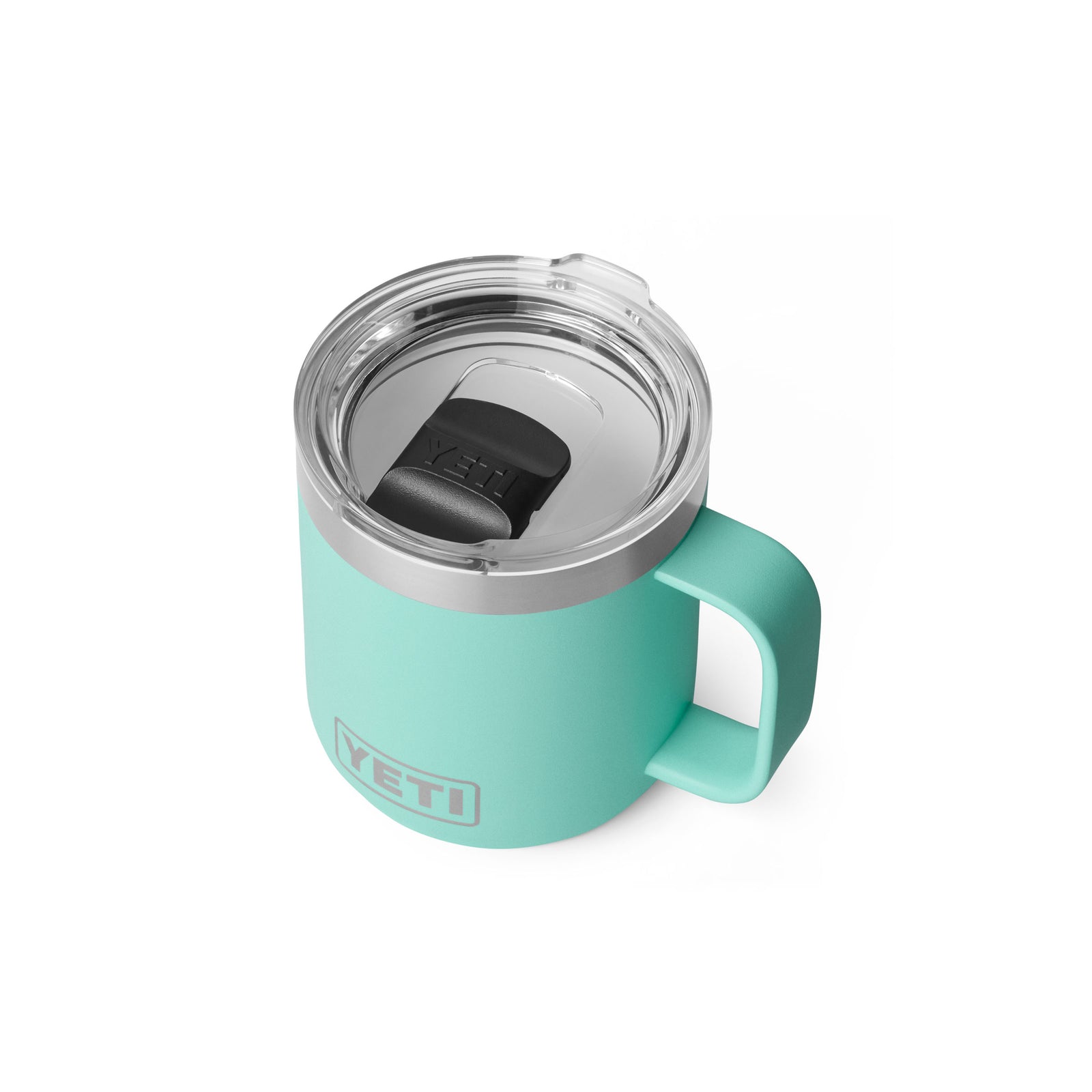 Der YETI® Tasse Rambler 10 Oz in Seafoam ist ein Becher mit Henkel und transparentem Deckel mit einem schwarzen Schieber. Dieser YETI-Becher bietet doppelwandige Vakuumisolierung für optimale Temperaturerhaltung, dargestellt auf weißem Hintergrund.