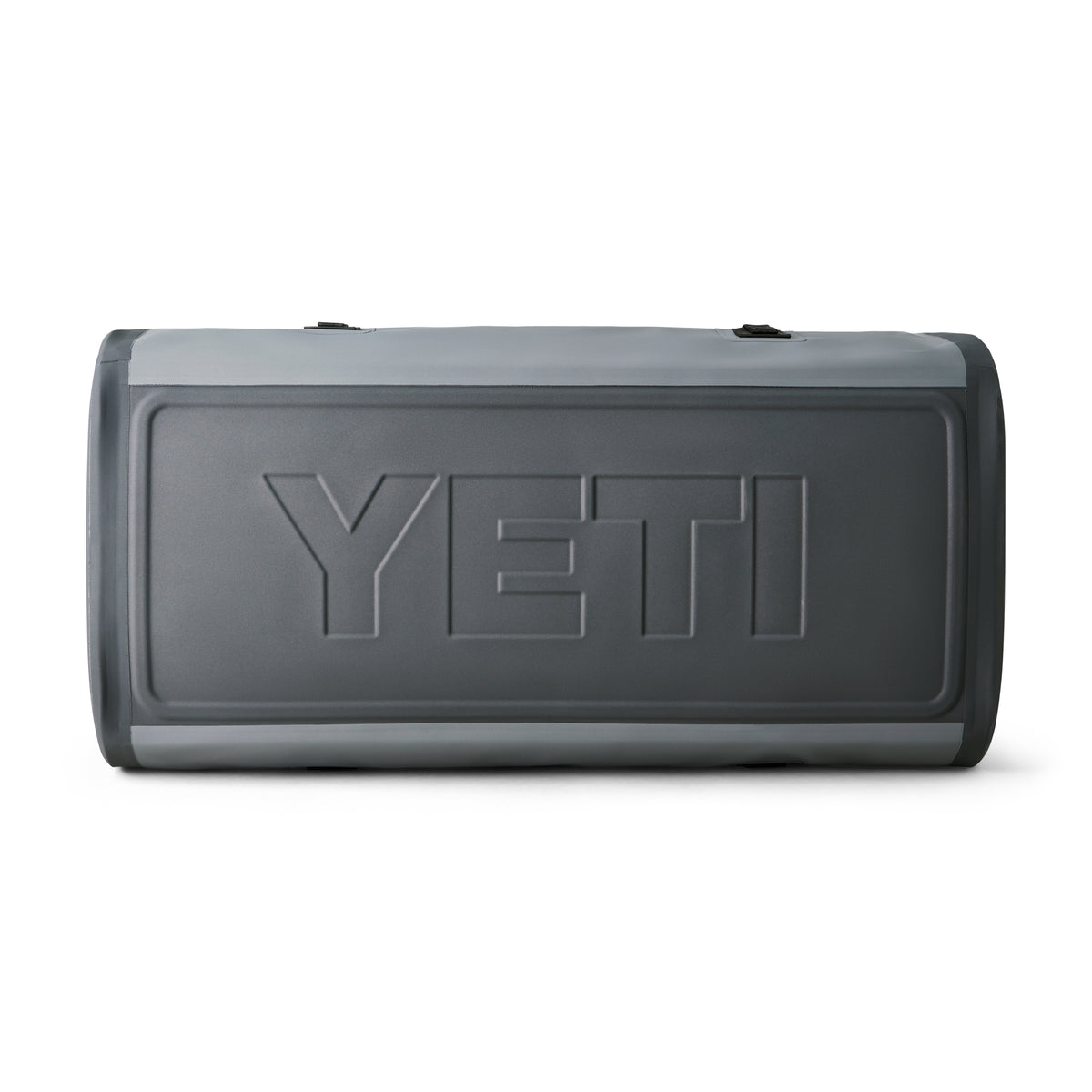 Eine YETI® Reisetasche Panga 100 in Storm Grey liegt auf der Seite, das markante YETI-Logo ist sichtbar. Diese wasserdichte Tasche wirkt einfach, ohne Reißverschlüsse oder Griffe aus diesem Blickwinkel.