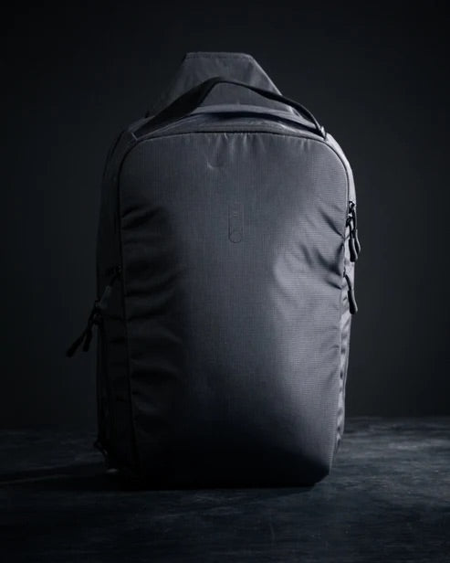 Der EBERLESTOCK Fade Sling XL Rucksack besticht durch sein schlankes, minimalistisches schwarzes Design mit sichtbaren Seitenreißverschlüssen und steht aufrecht auf einer dunklen Oberfläche - ideal für Fans der EDC-Ausrüstung.