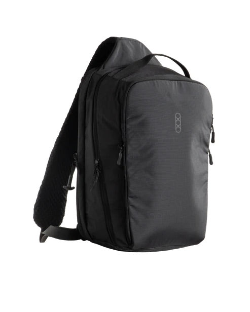 Die EBERLESTOCK Fade Sling XL ist eine schwarze Umhängetasche mit einem Griff an der Oberseite, mehreren Reißverschlussfächern und einem gepolsterten Schultergurt - ideal für den Transport Ihrer EDC-Ausrüstung, hier vor einem weißen Hintergrund.