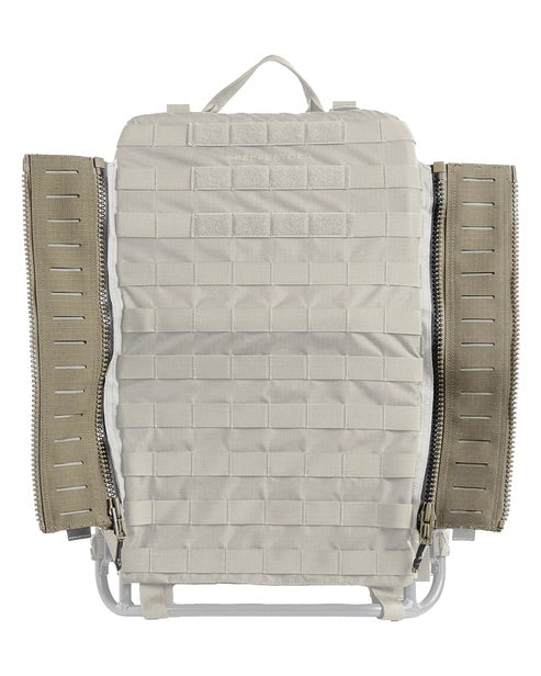 Ein hellbrauner EBERLESTOCK Rucksack mit MOLLE-Gewebe auf der Vorderseite, zwei großen Seitenreißverschlüssen mit der Eberlestock EMOD Reissverschluss Erweiterung, die teilweise geöffnet sind, und einem stabilen Griff an der Oberseite.