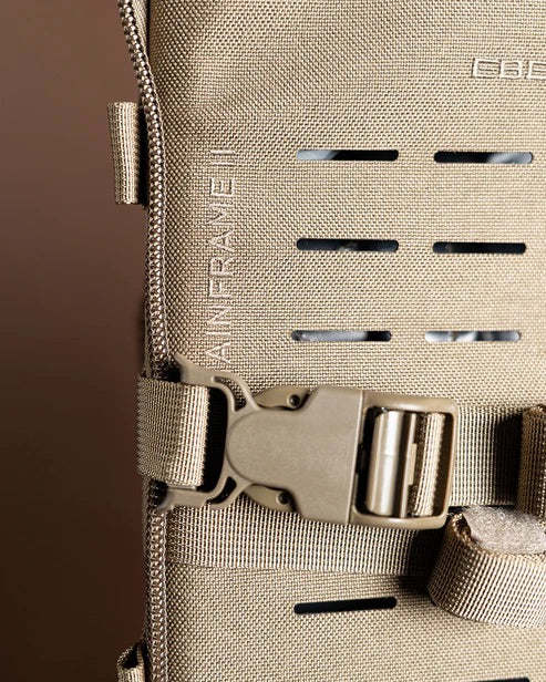 Nahaufnahme des taktischen Rucksacks Mainframe II von EBERLESTOCK mit horizontalen Schlitzen für modulare Befestigungen, Schnallenverschluss, dickem Reißverschluss und vertikal aufgenähtem "MAINFRAME II" - ideal als Jagd-Tragegestell.