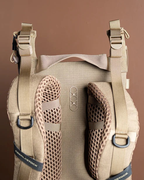 Eine Nahaufnahme des braunen Rucksacks Eberlestock Mainframe II von EBERLESTOCK zeigt gepolsterte, atmungsaktive Gurte, einen stabilen Griff und mehrere Schnallen - allesamt Merkmale, die für die Jagd gemacht sind.