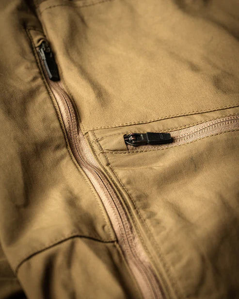 Nahaufnahme der EBERLESTOCK Deadwood Pant in Gunmetal. Sie zeigt zwei Reißverschlusstaschen mit schwarzen Zugbändern und hebt die Textur und die Nahtdetails des wasserabweisenden Stoffes hervor.