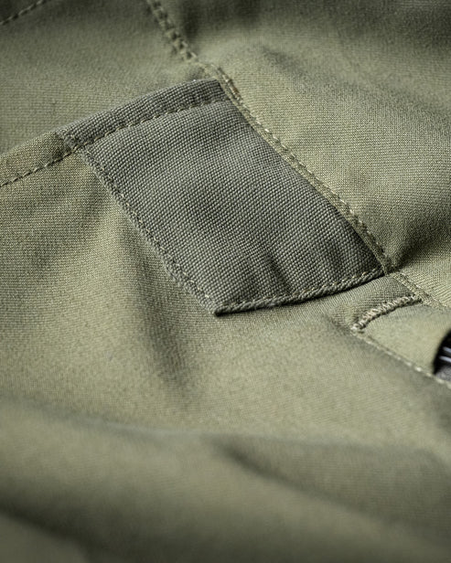 Nahaufnahme der EBERLESTOCK Camas Pro Pant in Rotgussoptik mit einer aufgenähten Tasche, die die robuste Struktur und die Nähte hervorhebt - ideal für den taktischen oder jagdlichen Einsatz.