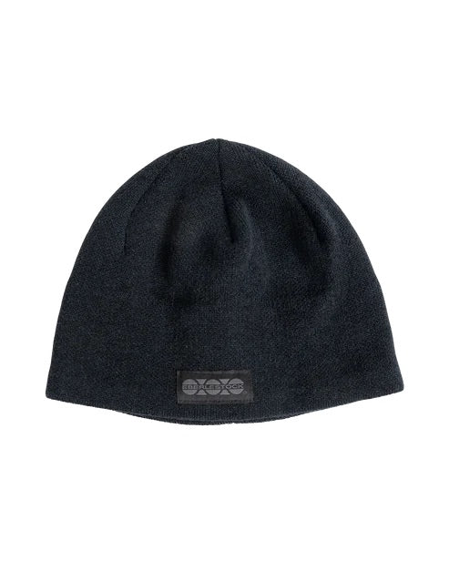 Die EBERLESTOCK North Fork Merino Beanie ist eine schlichte schwarze Strickmütze mit einem kleinen rechteckigen Aufnäher auf der Vorderseite, der ein dezentes Logo zeigt.
