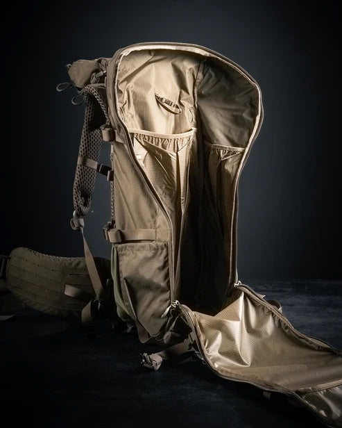 Die EBERLESTOCK Eberlestock Brute 4500 ist aufrecht mit vollständig geöffnetem Hauptfach abgebildet, das mehrere Innentaschen und Mesh-Organizer vor einem dunklen Hintergrund offenbart.