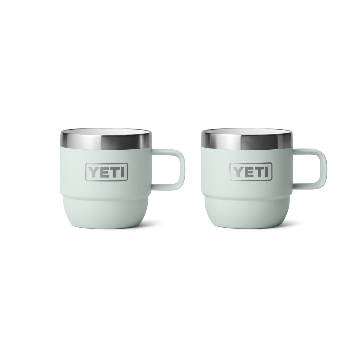 Zwei Ridgeline YETI® Espresso-Tasse Rambler 6 Oz (2er Pack) in hellgrün, mit Henkeln und Edelstahlrändern, stehen nebeneinander auf weiß. Jeder Becher verfügt über das YETI-Logo und Vakuumisolierung, um Getränke auf der perfekten Temperatur zu halten.