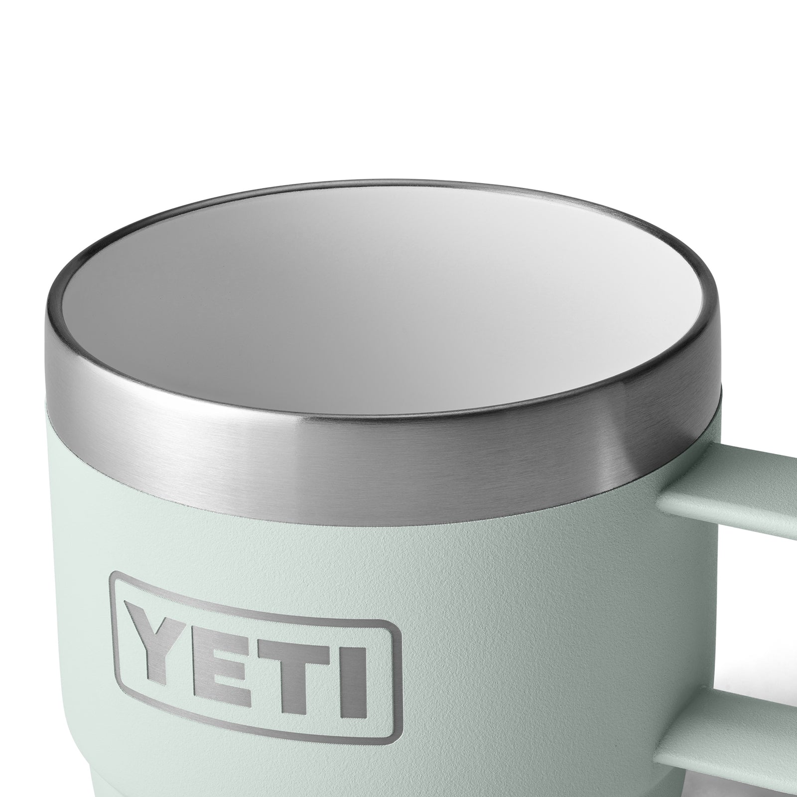 Eine Nahaufnahme einer blassmintgrünen YETI® Espresso-Tasse Rambler 6 Oz (2er Pack) - Ridgeline mit Vakuumisolierung, Edelstahlrand, weißem Innenraum, strukturierter Außenseite und dem YETI-Logo.