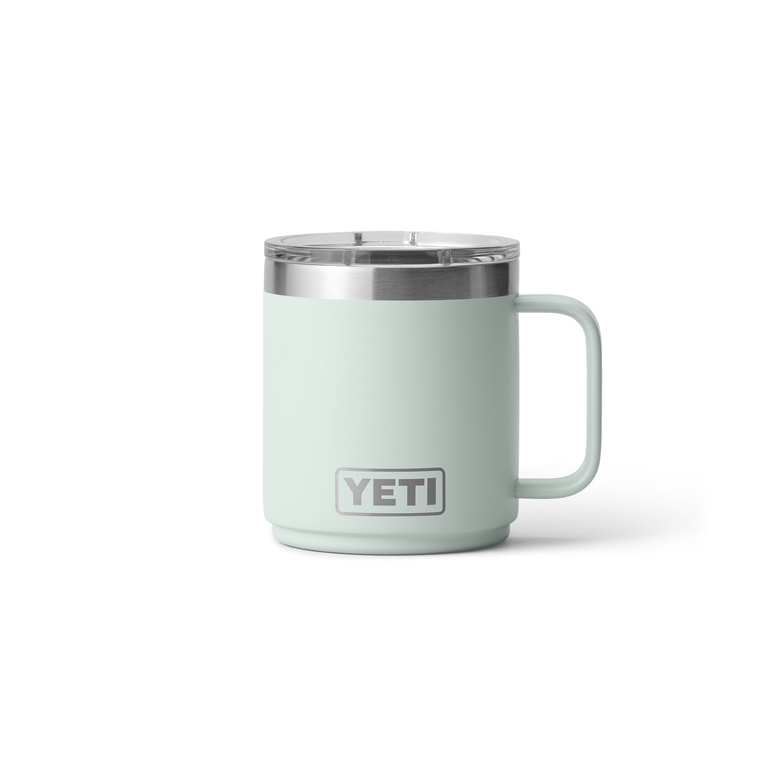Eine YETI® Tasse Rambler 10 Oz - Ridgeline in mintgrün mit Griff und Edelstahlrand, mit doppelwandiger Vakuumisolierung und einem transparenten Deckel, abgebildet vor einem schlichten weißen Hintergrund.