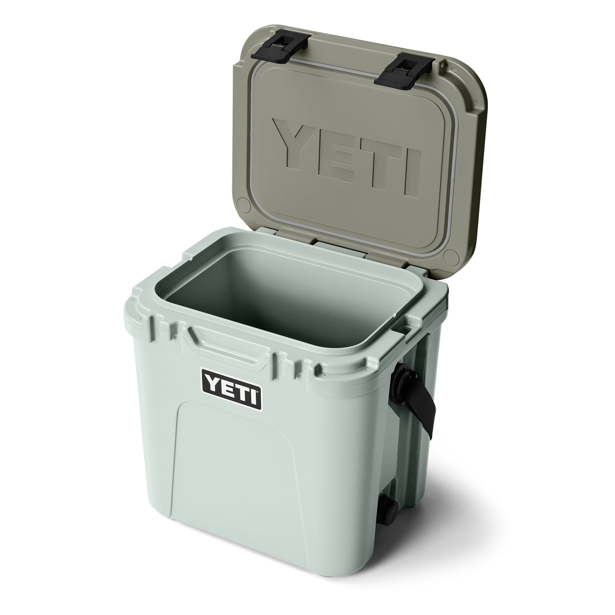 Die hellgraue YETI® Kühlbox Roadie 24 - Ridgeline ist offen und leer abgebildet und trägt das YETI-Logo auf der Innenseite und Vorderseite des Deckels. Diese erstklassige Camping-Kühlbox verfügt über PermaFrost Isolierung für zuverlässige Isolierung.