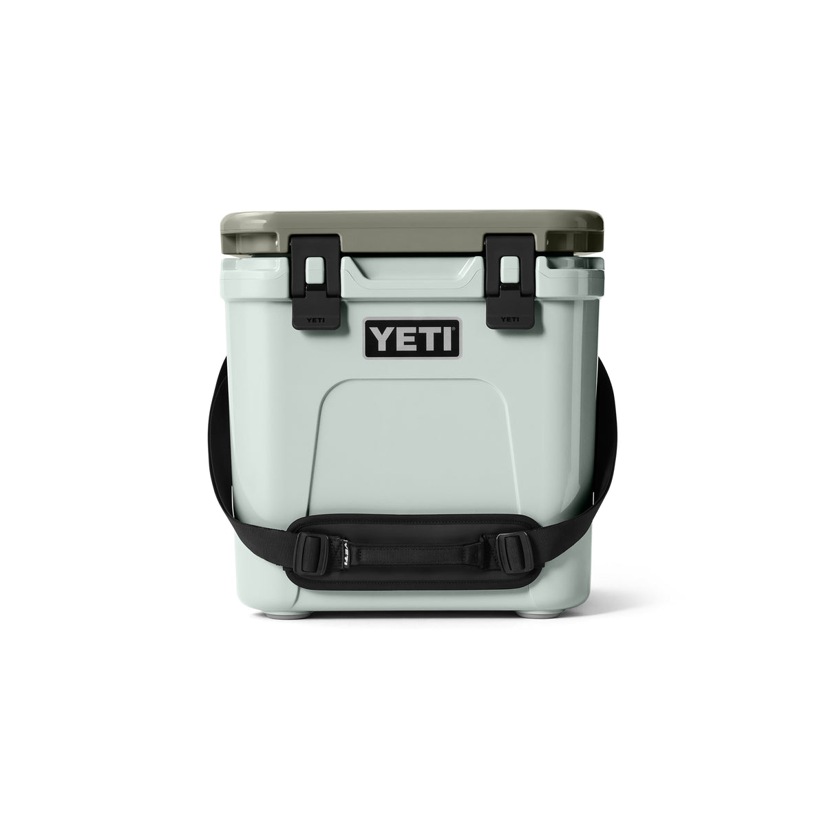Die YETI® Kühlbox Roadie 24 - Ridgeline hat einen hellgrauen Korpus, einen dunkelgrauen Deckel, schwarze Seitenverschlüsse und einen verstellbaren schwarzen Schultergurt mit PermaFrost Isolierung - ideal für den Einsatz beim Camping, abgebildet auf weißem Hintergrund.