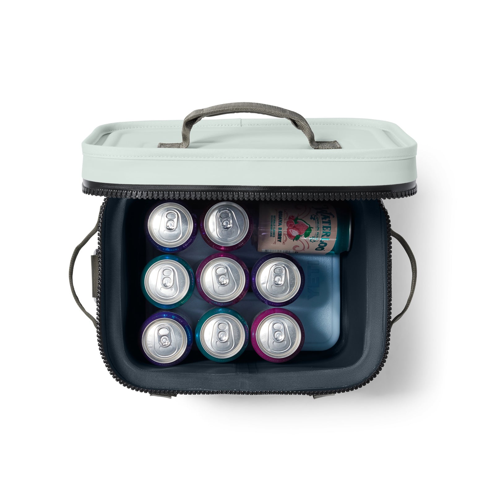 Draufsicht auf eine geöffnete YETI® Kühltasche Hopper Flip® 12 - Ridgeline mit neun Dosen und einem blauen Kühlakku im Inneren. Die hellgraue, auslaufsichere Kühltasche von YETI verfügt über einen Reißverschluss und Tragegriffe.