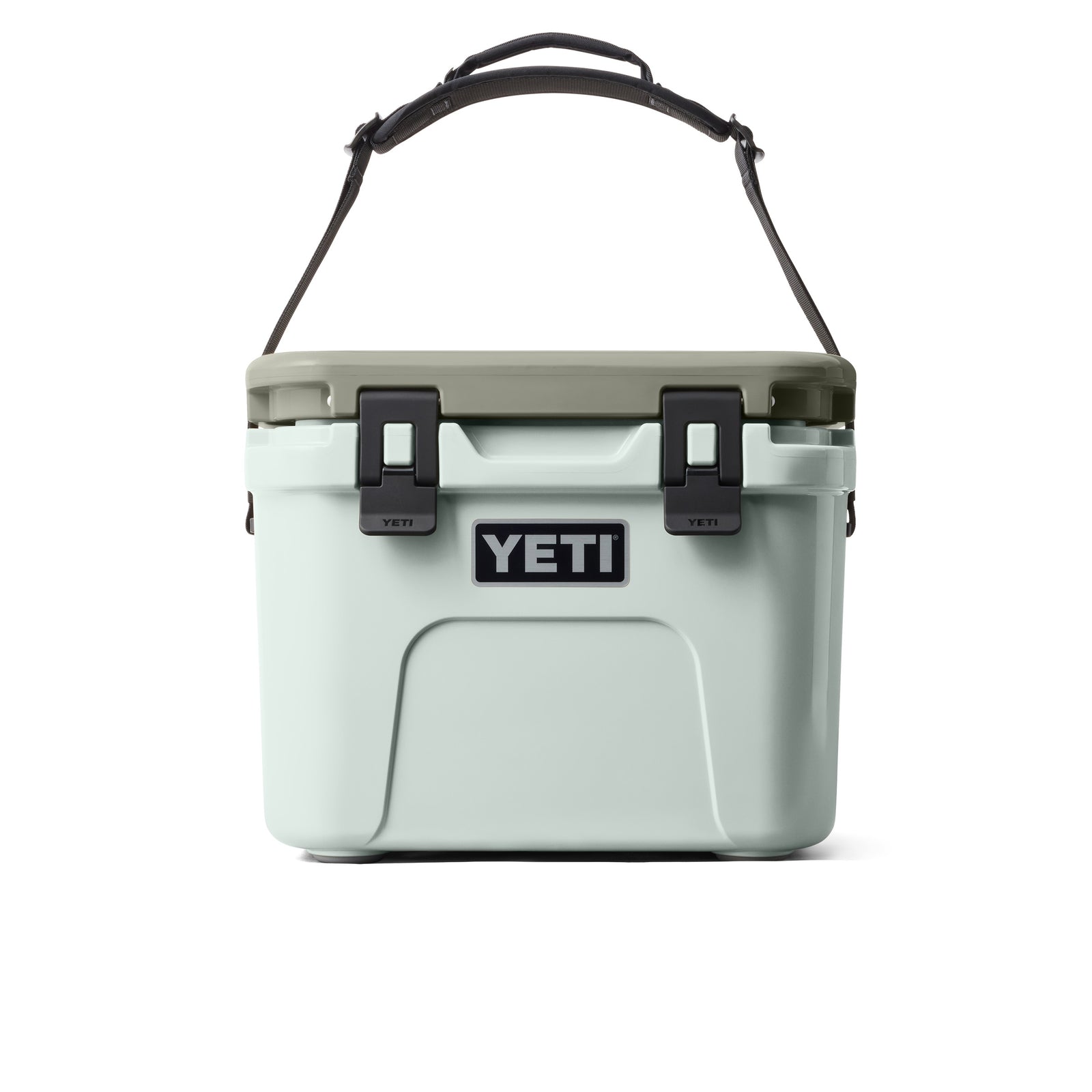 Die YETI® Kühlbox Roadie 15 - Ridgeline ist eine hellblaue Kühlbox mit einem grauen Deckel, einem schwarzen Griff und zwei schwarzen Frontverschlüssen. Das YETI-Logo ist in der Mitte dieser Outdoor-Kühlbox gut sichtbar angebracht.