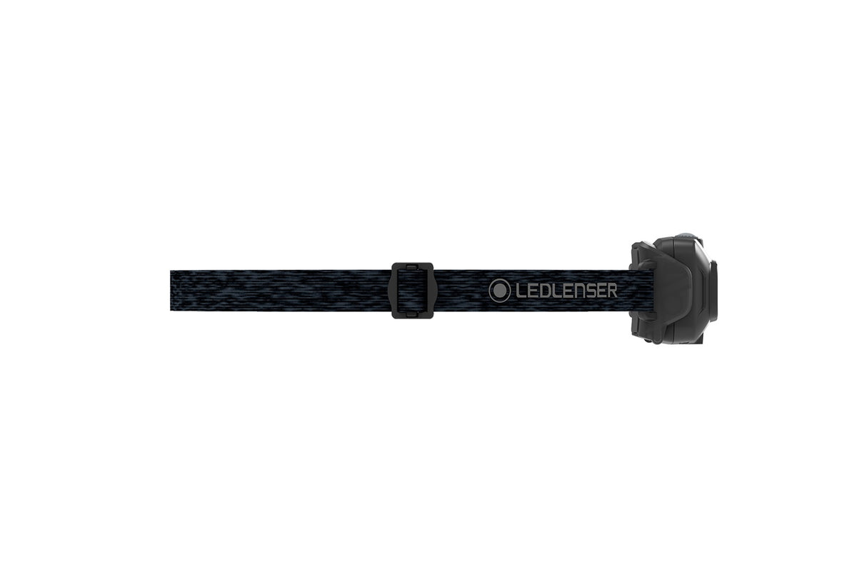 Eine schwarze LEDLENSER Stirnlampe HF4R Core mit verstellbarem Gurt ist in der Seitenansicht auf weißem Hintergrund zu sehen, wobei die LED-Einheit am vorderen rechten Ende des Gurtes angebracht ist.