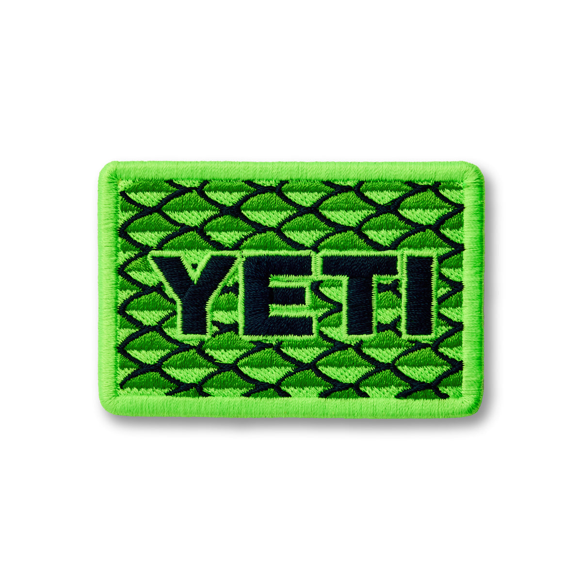 Der YETI® Scales Patch ist ein rechteckiger grüner Aufnäher mit einem Fischschuppenmuster und dem Schriftzug "YETI" - ideal für Ihre Outdoor-Ausrüstung.
