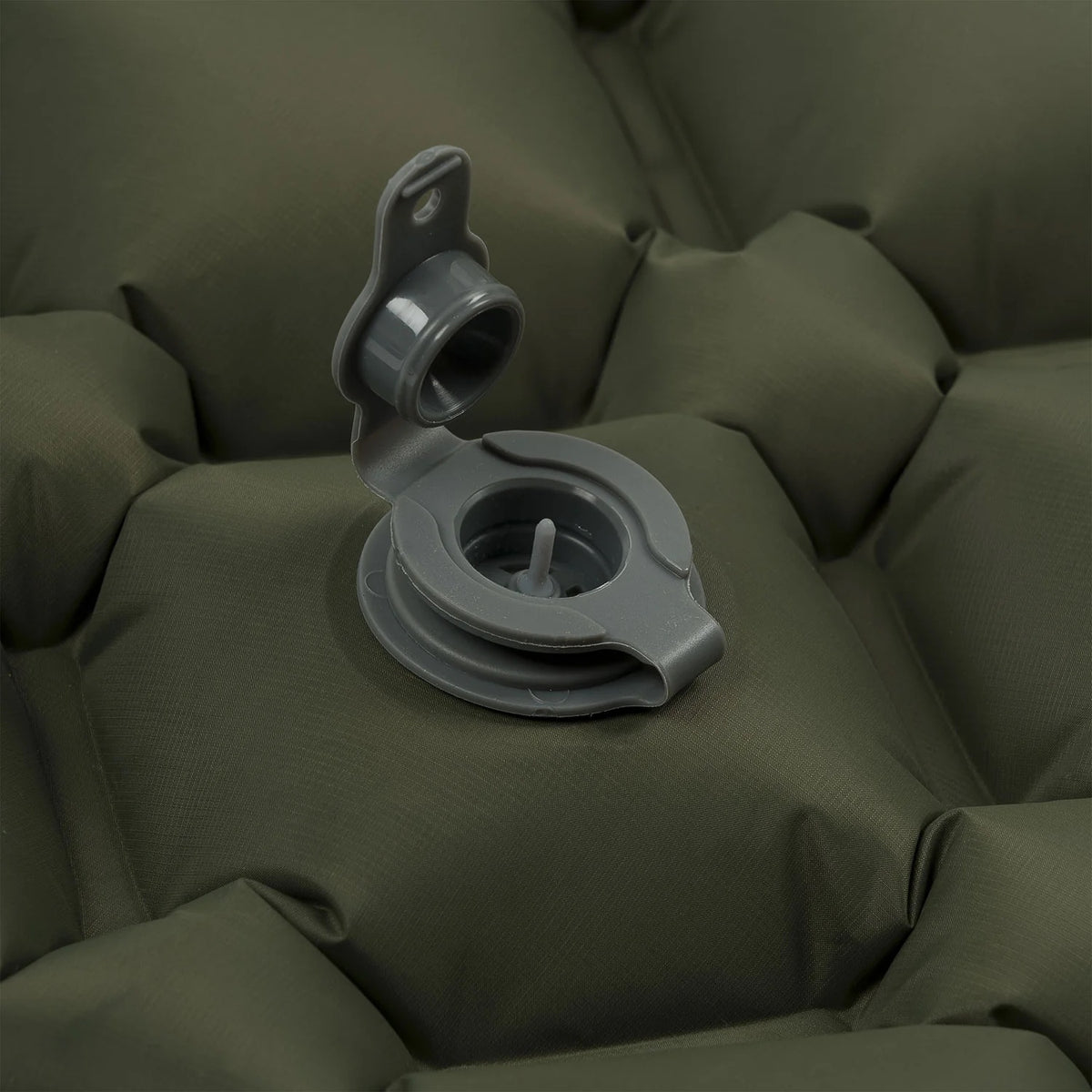 Nahaufnahme eines offenen Luftventils auf der HIGHLANDER FORCES Highlander NAP PAK aufblasbare Schlafmatte mit PrimaLoft in Olivgrün, mit einer strukturierten, gesteppten Oberfläche - perfekt für den Komfort beim Outdoor-Camping.