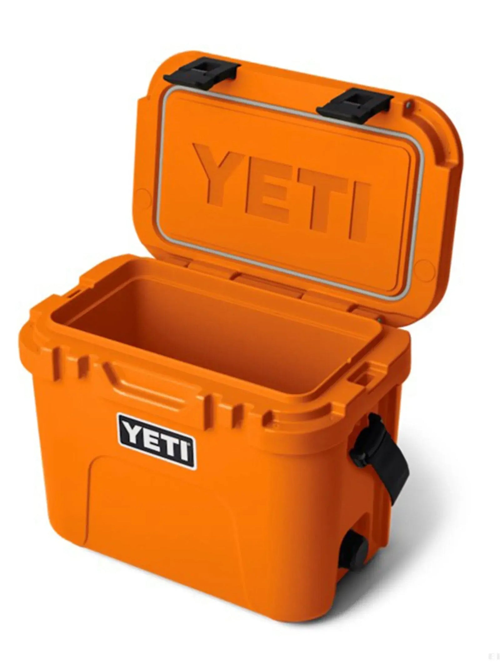 Eine orangefarbene YETI® Kühlbox Roadie 15 - King Crab mit offenem Deckel zeigt das YETI-Logo auf dem Deckel und der Vorderseite. Die robuste Outdoor-Kühlbox hat stabile schwarze Verschlüsse und seitliche Griffe zum einfachen Tragen.