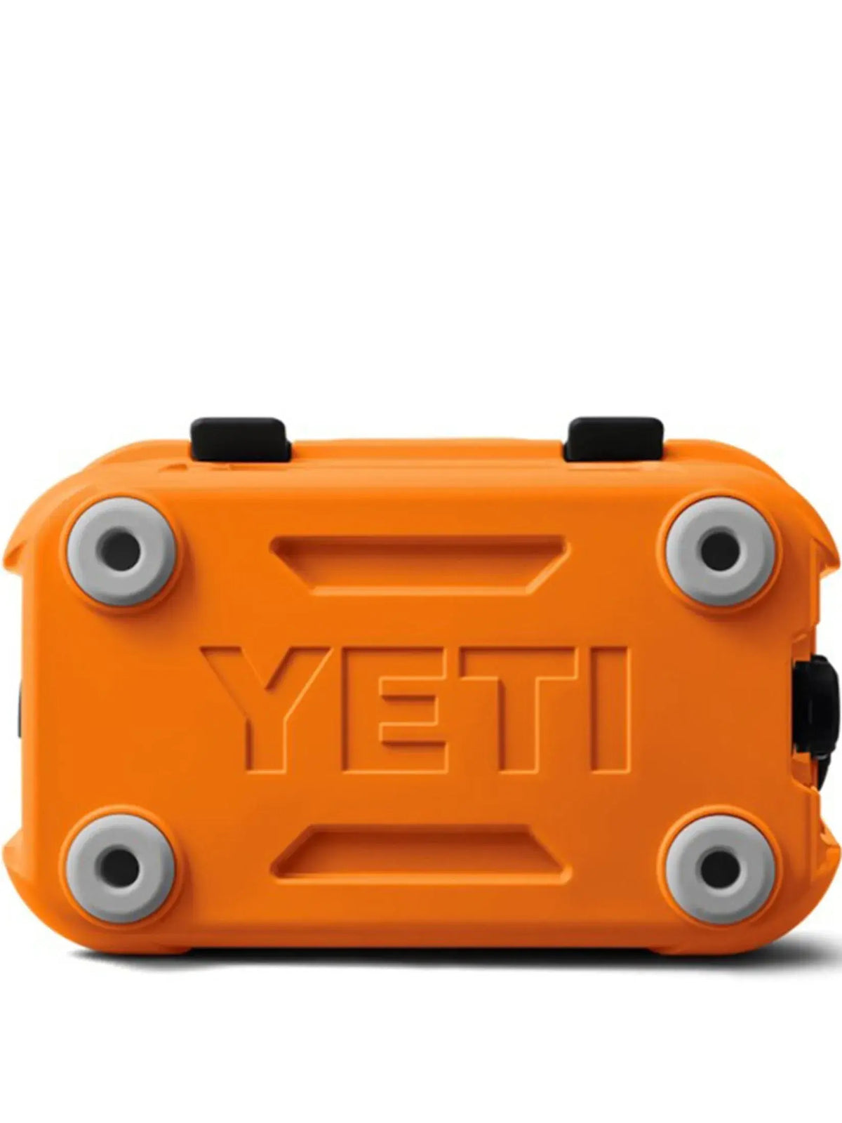 Die YETI® Kühlbox Roadie 15 - King Crab wird von unten gezeigt, mit vier grauen runden Füßen an jeder Ecke und dem geprägten YETI-Logo in der Mitte des Bodens.