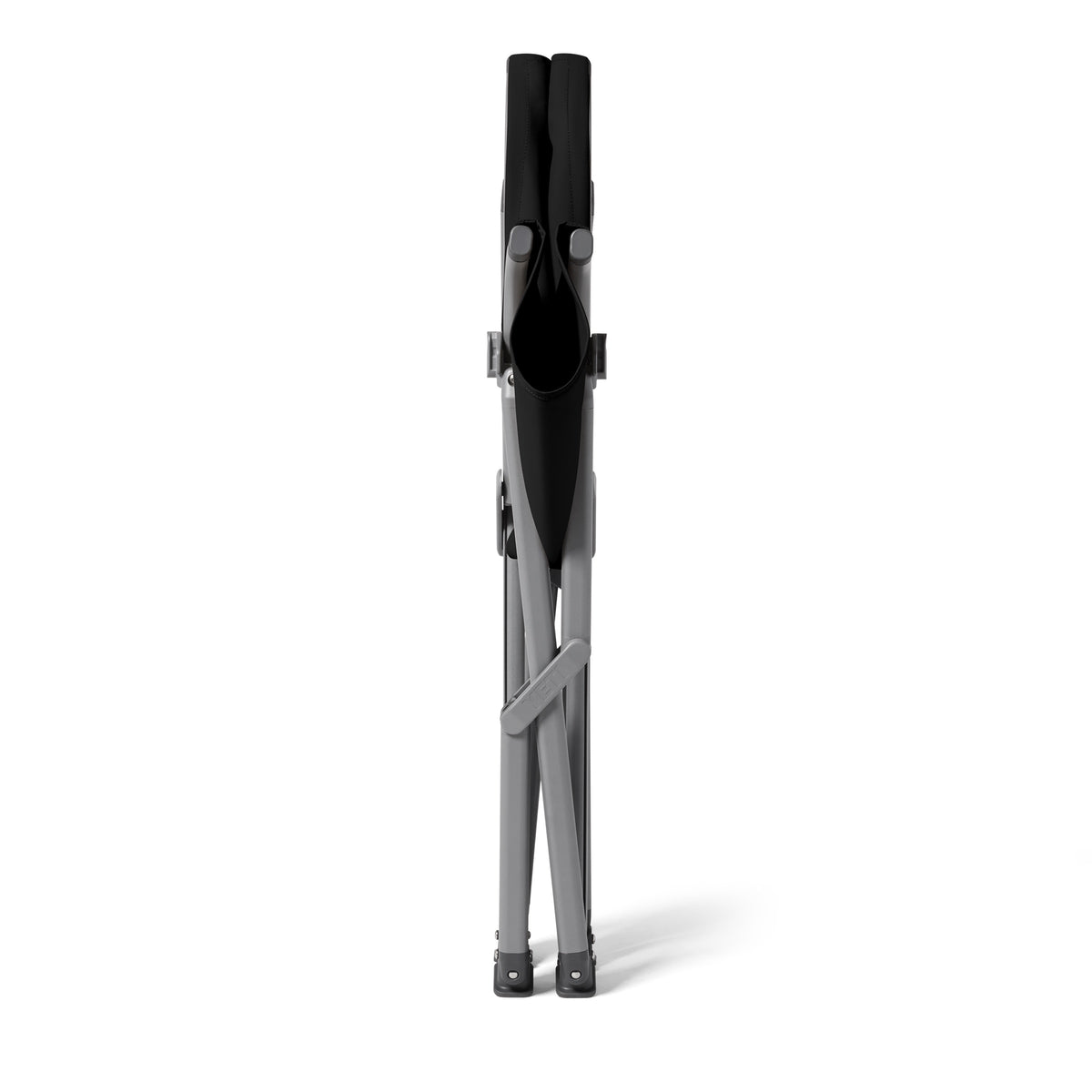 Ein zusammengefalteter YETI® Camping Stuhl Trailhead Field - Black von YETI steht aufrecht auf weißem Hintergrund, von vorne gesehen mit zusammengeklappten Beinen und Sitz.