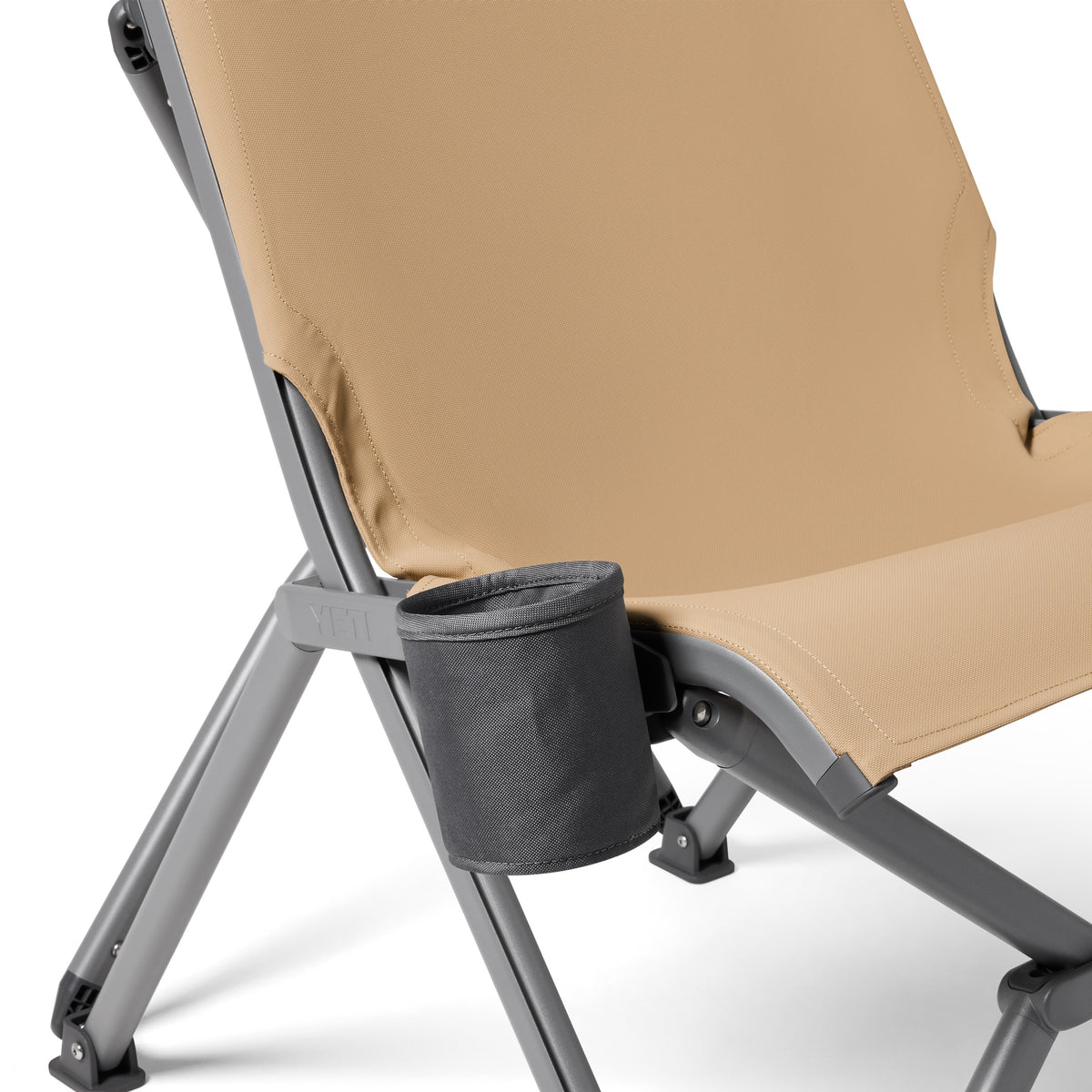Eine Nahaufnahme des YETI® Camping Stuhl Trailhead Field - Tan, mit einem robusten grauen Metallrahmen und einem abnehmbaren schwarzen Becherhalter - perfekt zum Entspannen im Freien.