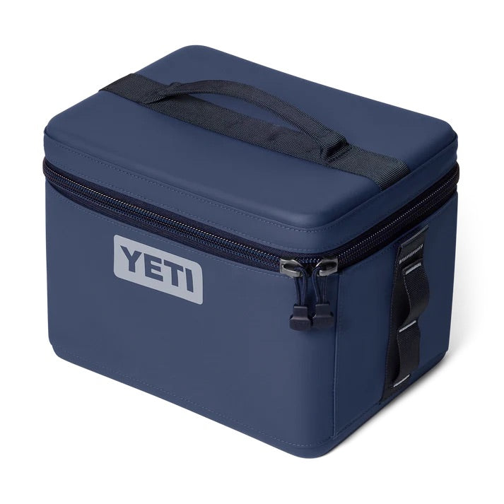 Die YETI® Kühltasche Daytrip 9L in Classic Navy verfügt über einen Reißverschluss oben, einen schwarzen Griff, einen Seitenriemen und ein weißes YETI-Logo - ideal als kompakte Isothermbox oder Lunchbox für Ihre Ausflüge.