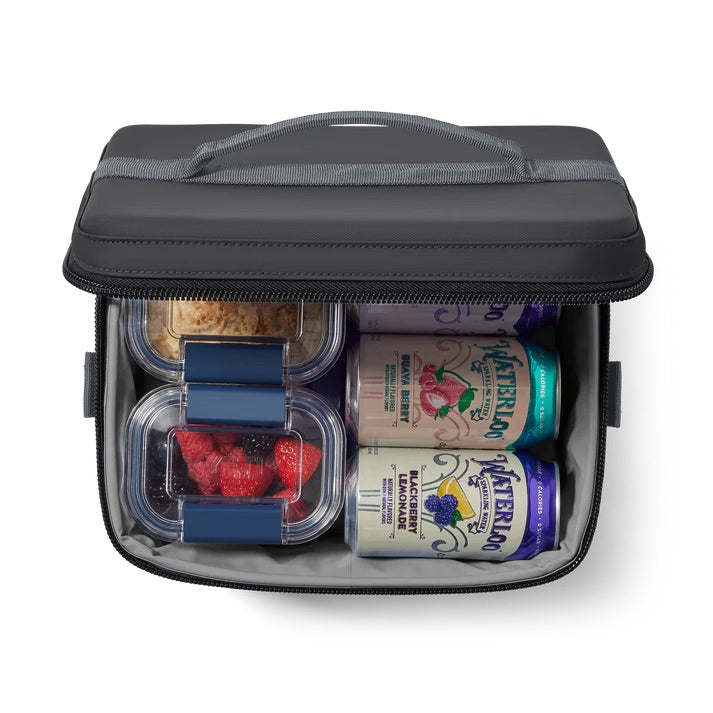 Eine YETI® Kühltasche Daytrip 9L - Charcoal, offen und von oben gesehen, fasst Beeren, Müsli in zwei Behältern, plus zwei Waterloo Sprudelkannen - von YETI fachmännisch frisch verpackt.