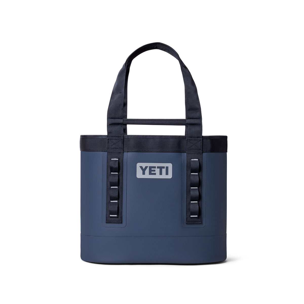Die YETI® Tragetasche Camino® Carryall 35 in Classic Navy ist eine robuste, wasserdichte Allzwecktasche mit schwarzen Tragegriffen, schwarzer Einfassung, einem rechteckigen YETI-Logo auf der Vorderseite und vertikalen schwarzen Schlaufen neben dem Logo.